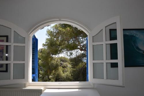 an open window with a view of a tree at Villa Iokasti (sea view) in Pefkali
