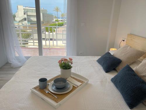 ein Tablett mit einem Teller Essen auf dem Bett in der Unterkunft Apartamento con vistas al Mediterraneo in Jávea