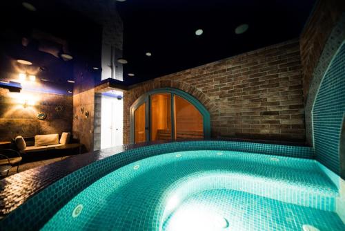 a swimming pool in a room with a brick wall at Ati Ambavi Botique Hotel Gudauri in Gudauri