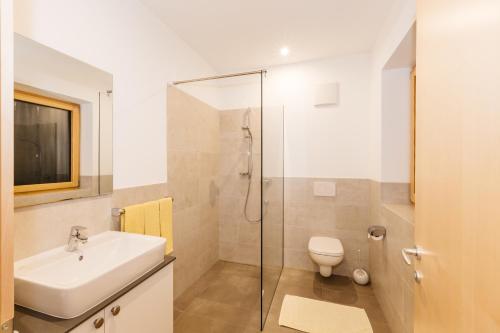 ein Bad mit einer Dusche, einem Waschbecken und einem WC in der Unterkunft Appartement Florian in Kaltern