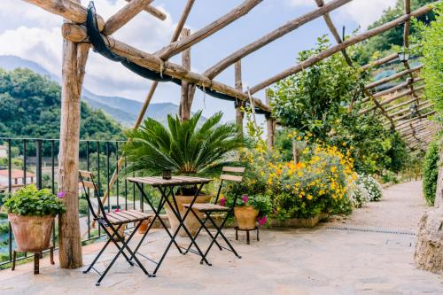 a patio with chairs and tables and plants at Villa Le Murelle in Tramonti