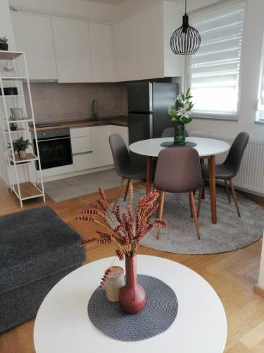 eine Küche und ein Wohnzimmer mit einem Tisch und Stühlen in der Unterkunft Apartman Lukana lll Banjaluka in Banja Luka