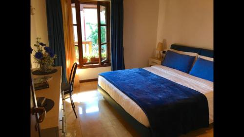 um quarto com uma cama com lençóis azuis e uma janela em Splendido cottage Lakeview em Bellagio