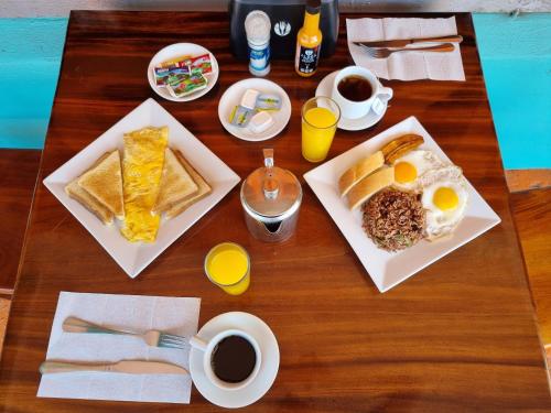 einen Tisch mit zwei Tellern Frühstückslebensmittel und Kaffee in der Unterkunft Hotel Aldea Chorotega Puntarenas in Puntarenas