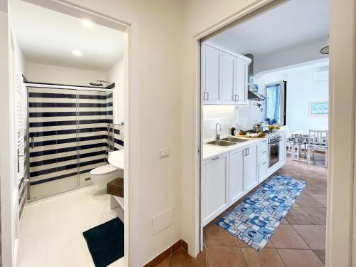 a white kitchen with a sink and a toilet at villa olimpia in Nerano
