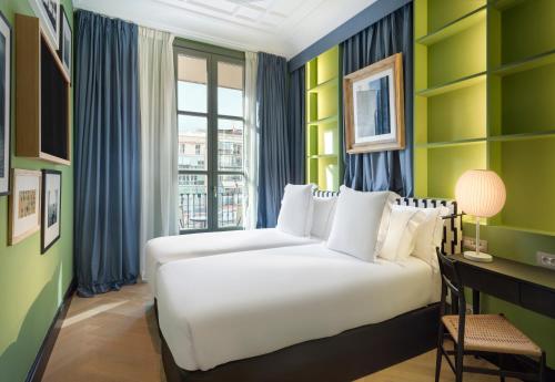 a hotel room with two beds and a window at One Shot Aragó 257 in Barcelona