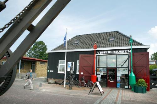 a man walking in front of a building at Vakantiehuisjes Robersum in Vierhuizen