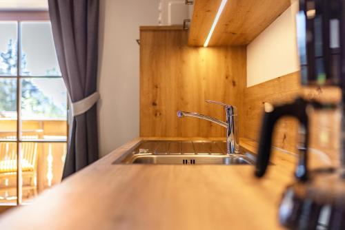 um balcão de cozinha com um lavatório e uma janela em Lechnerhof Wilde Kreuzspitze em Valles