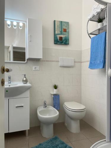 a white bathroom with a toilet and a sink at Old Town Lemon Charm in Bordighera