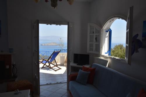a living room with a blue couch and a view of the ocean at Villa Iokasti (sea view) in Pefkali