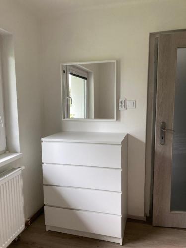 a white dresser with a mirror on top of it at Venkovský dům Dolní Přím in Dolní Přím