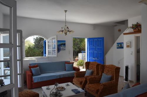 a living room with a blue couch and chairs at Villa Iokasti (sea view) in Pefkali