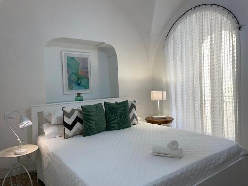 a bedroom with a large white bed with green pillows at Old Town Lemon Charm in Bordighera