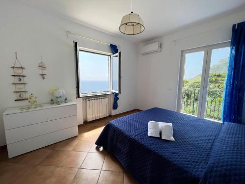 a bedroom with a blue bed and a large window at villa olimpia in Nerano