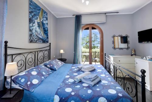 a bedroom with a bed with a blue comforter at Villa Gaia in Bordighera