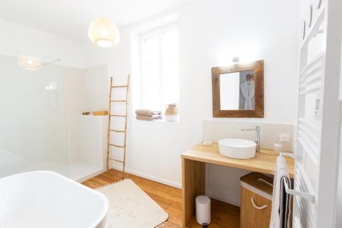 La salle de bains est pourvue d'un lavabo et d'un miroir. dans l'établissement La Villa Mora SPA, à Lisieux