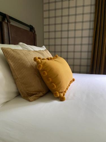 a teddy bear sitting on a bed with two pillows at Berkshire Valley Inn in North Hancock