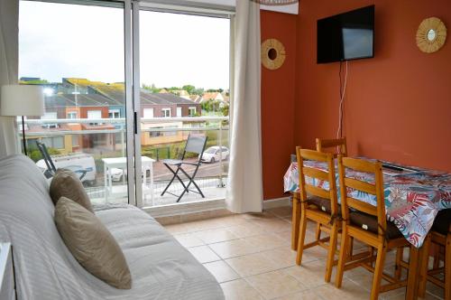 sala de estar con sofá y balcón en Appartement au pied de la plage - Balcon - Parking, en Courseulles-sur-Mer