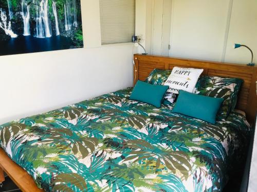 una camera con letto e copriletto tropicali di Plumeria holidays a Saint-Pierre