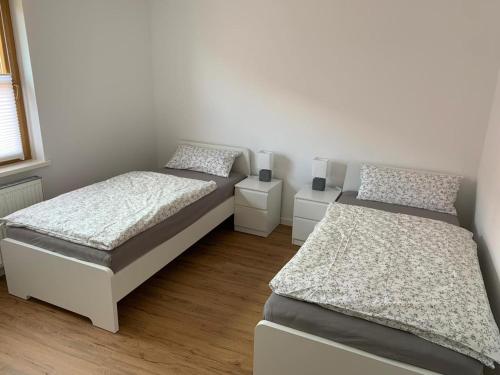 a bedroom with two beds and two night stands at Ferienwohnung Rosenberger in Kolitzheim