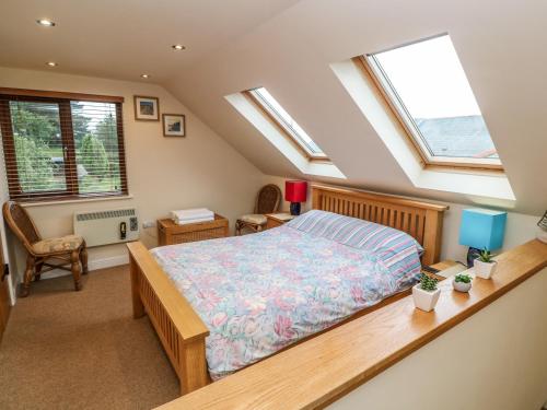 a bedroom with a bed and two windows at Sunswept in St Austell