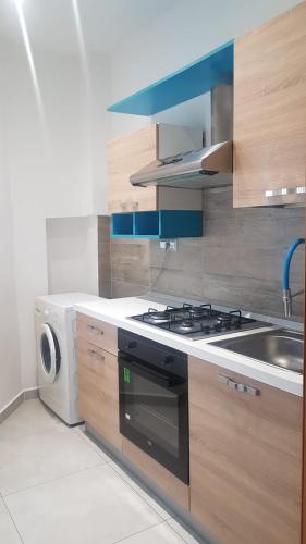 a kitchen with a stove and a washing machine at Appartamento Fronte Mare in Falconara Marittima