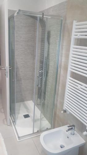 a shower with a glass door next to a sink at Appartamento Fronte Mare in Falconara Marittima