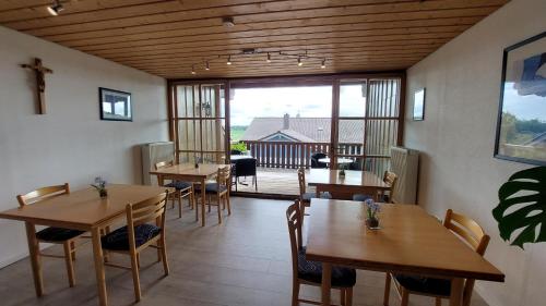 una sala da pranzo con tavoli e sedie e un balcone di Privatpension Eberth a Bogen