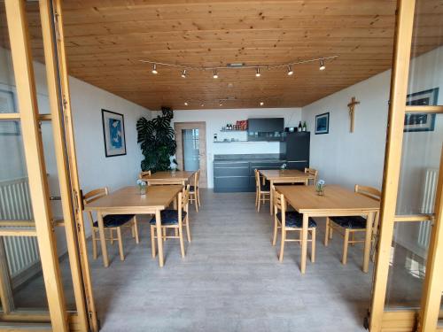 a restaurant with wooden tables and chairs and a kitchen at Privatpension Eberth in Bogen
