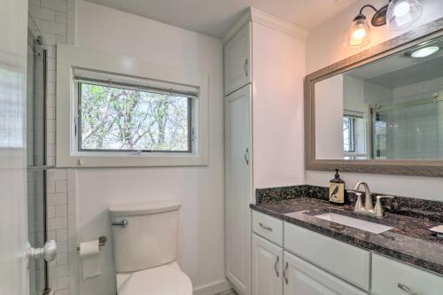 a bathroom with a toilet and a sink and a mirror at Serene Cape Cod Escape with Private Ocean Overlook! in Mashpee