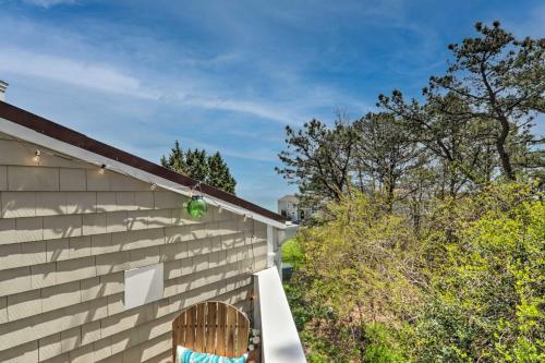 a wooden chair sitting on the side of a house at Serene Cape Cod Escape with Private Ocean Overlook! in Mashpee