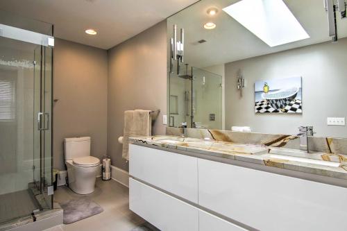 a bathroom with two sinks and a toilet and a mirror at Bayfront Gem with Amazing Water Views and Pond! in Madison
