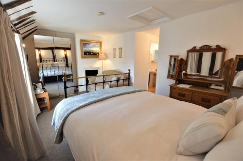 ein Schlafzimmer mit einem großen Bett und einem Spiegel in der Unterkunft Chantry Hotel in Bury Saint Edmunds