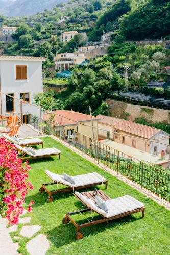 a group of chaise lounges on the grass on a hill at Villa Le Murelle in Tramonti