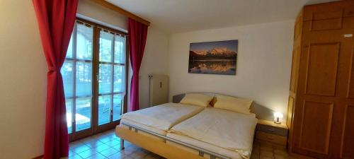 a bedroom with a bed and a large window at Ferienwohnungen Romeo-Julio-Mittenwald in Mittenwald