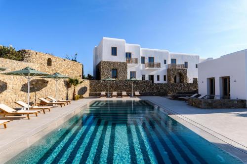 une villa avec une piscine en face d'un bâtiment dans l'établissement Camarades Mykonos, à Ano Mera