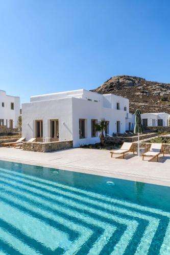 a villa with a swimming pool next to a house at Camarades Mykonos in Ano Mera