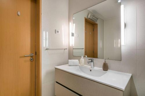 La salle de bains est pourvue d'un lavabo et d'un miroir. dans l'établissement Dragon Stadium Studio w Balcony by LovelyStay, à Porto