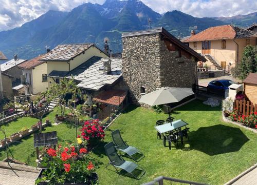 an outdoor patio with a table and chairs and mountains at Senin House in Aosta