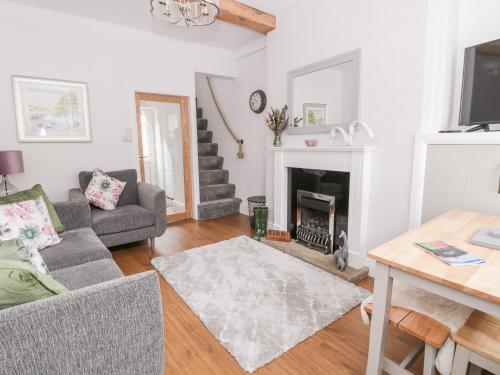 a living room with a couch and a fireplace at Ermysted's Cottage in Skipton