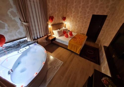 a bedroom with a tub and a bed with red balloons at Yıldız Hotel in Urgup