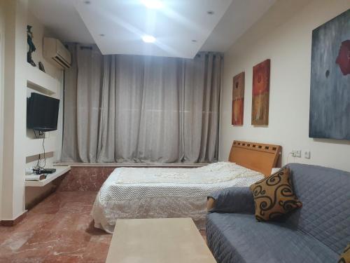 a bedroom with a bed and a couch at Ezore Yam Apartmens - Elmali'akh St. 4 in Bat Yam