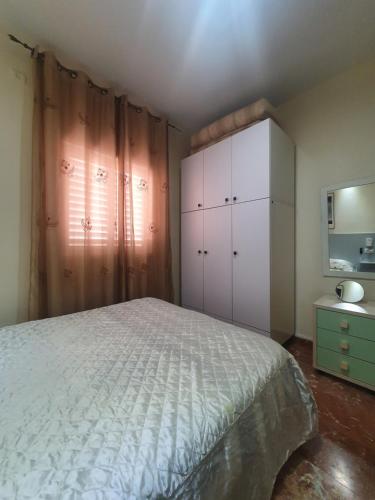 a bedroom with a bed and a cabinet and a television at Ezore Yam Apartmens - Elmali'akh St. 4 in Bat Yam