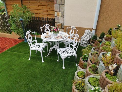a patio with a table and chairs and potted plants at Bükki Villa in Bükkszék