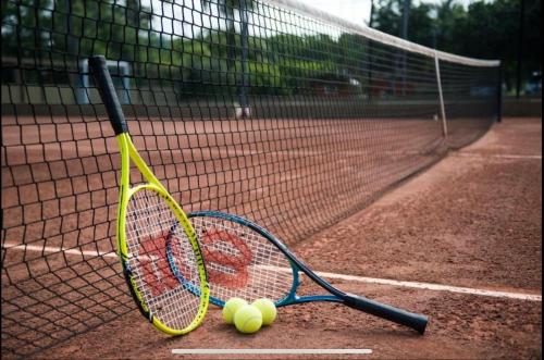 zwei Tennisschläger und -bälle auf einem Tennisplatz in der Unterkunft Porto de Galinhas Resort Marulhos in Porto De Galinhas