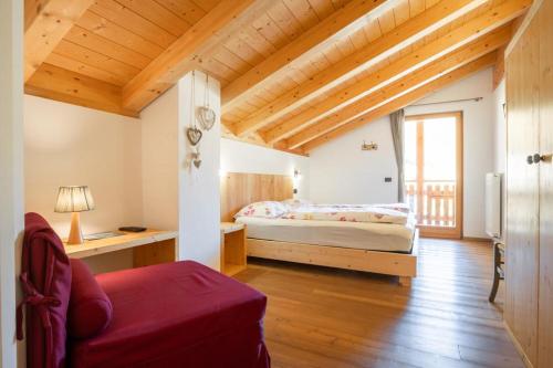 1 dormitorio con cama y techo de madera en Garnì dal Mozat, en Ledro
