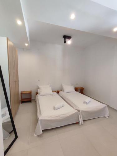 two beds in a room with white walls at Villa Areti in Lefkimmi