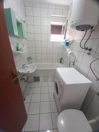 a white bathroom with a toilet and a sink at Apartman Ana in Trebinje
