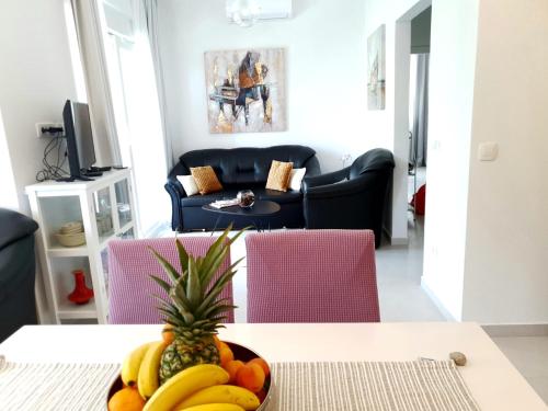 - un bol de fruits sur une table dans le salon dans l'établissement Orchid SeaView Apartment With Garage Parking, à Zaton