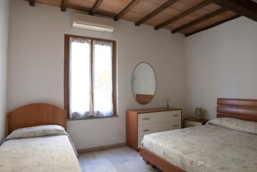 a bedroom with two beds and a window at Appartamenti LEVANTE e LIBECCIO in Follonica